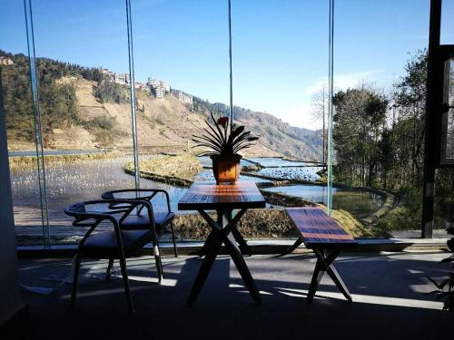 a table and chairs in front of a large window at Beyond the Terrace Residence in Yuanyang