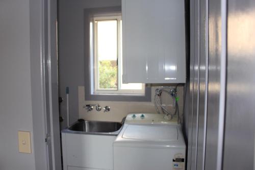 a small kitchen with a sink and a window at Aqualuna Apartments in Coffs Harbour