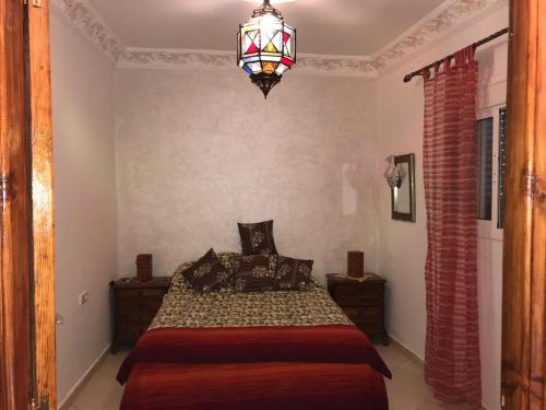 a bedroom with a bed and a chandelier at appartement traditionnel et contemporain, au coeur du kasbah in Tangier