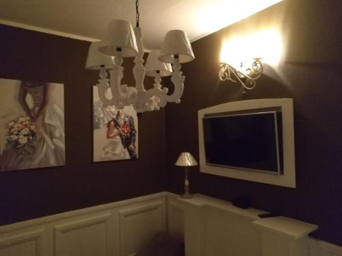 sala de estar con TV y lámpara de araña en sweet home en Biella