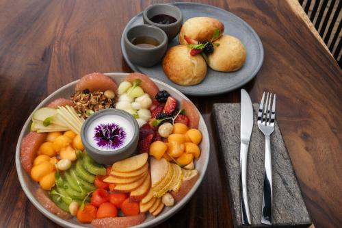 twee borden met eten met fruit en groenten op een tafel bij Koanze Luxury Hotel & Spa in Atemajac de Brizuela