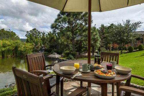 een houten tafel met een fruitschaal en een paraplu bij Koanze Luxury Hotel & Spa in Atemajac de Brizuela