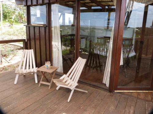 two white chairs and a table on a porch at Cabaña en la playa. ventanales y terraza al mar in Salinas 