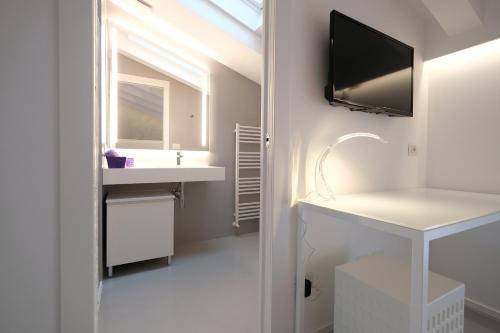 a bathroom with a sink and a tv on the wall at Villa Il Bacio del Sole in Verona