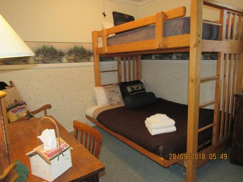 a bedroom with bunk beds and a table with a desk at Apple Bear Cabin in Big Bear City