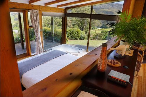 a bedroom with a bed and a desk with a window at Shanleys Huon Valley in Glendevie