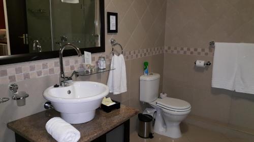 a white toilet sitting next to a sink in a bathroom at Villa Xanelle Boutique Guest House in Centurion