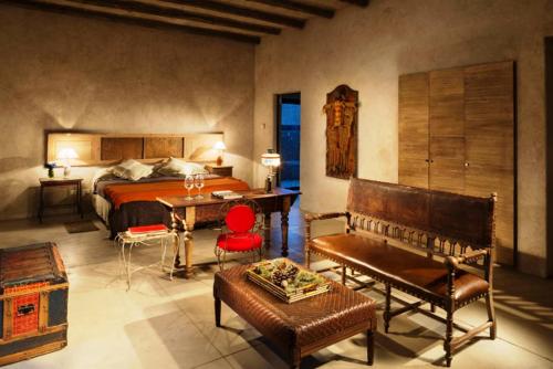 a bedroom with a bed and a table and chairs at Lodge Atamisque in San José