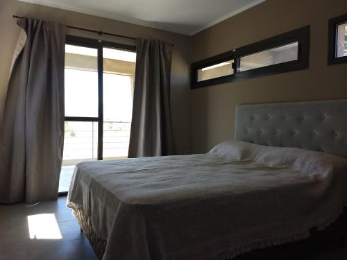 - une chambre avec un lit et une grande fenêtre dans l'établissement Waylla, à Panaholma