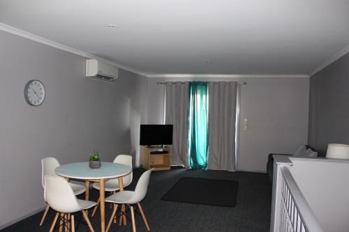 a living room filled with furniture and a tv at Aqualuna Apartments in Coffs Harbour