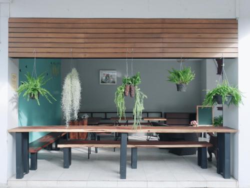 uma grande mesa de madeira com vasos de plantas em Pakchong Phubade Hotel em Pak Chong