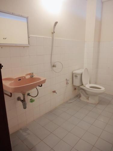 a bathroom with a toilet and a sink at Pakchong Phubade Hotel in Pak Chong