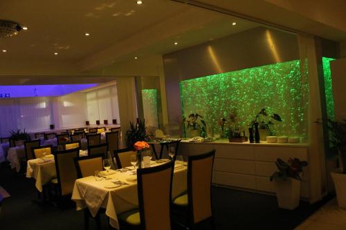 een eetkamer met tafels en een groene muur bij Ababeel Hotel in Birmingham