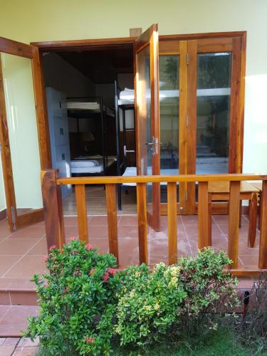 a porch with glass doors and a wooden railing at Free Beach Resort in Phu Quoc