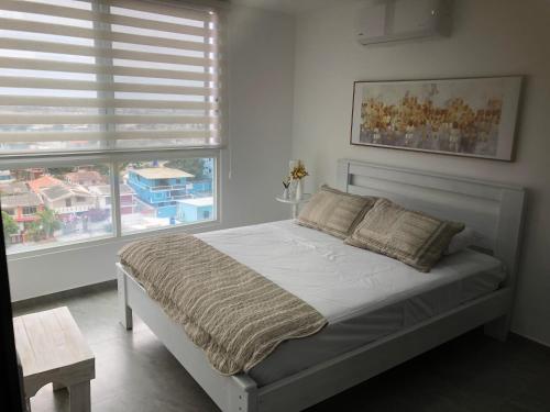 a bedroom with a bed and two windows at Torre Marbella apartamentos de 2 y 3 dormitorios in Salinas