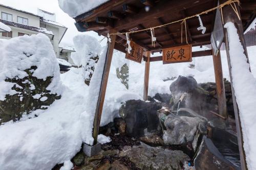 a temple in the snow with signs on it at Kansyokan in Mogami
