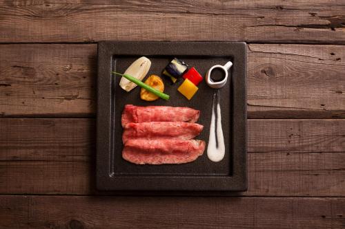 a plate of food with meat and vegetables on a table at Kansyokan in Mogami