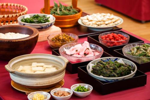 a table topped with bowls of different types of food at Kansyokan in Mogami