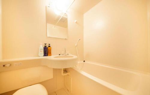 ein Badezimmer mit einem Waschbecken, einem WC und einer Badewanne in der Unterkunft Hotel Bouenkaku in Tome