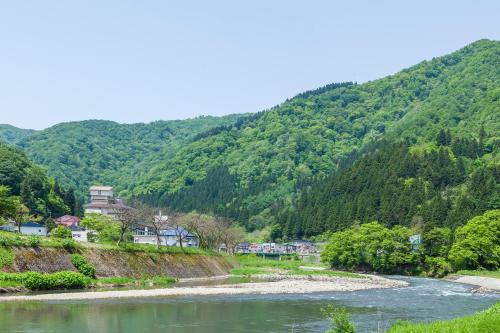 a river with a mountain in the background at Kansyokan in Mogami