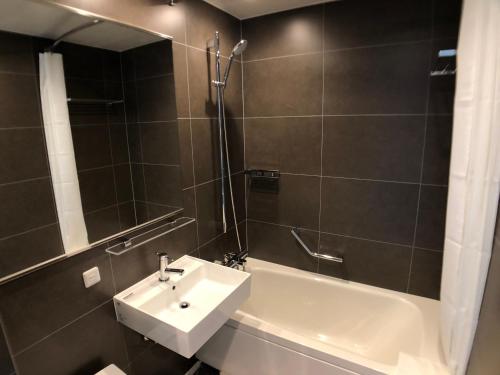 a bathroom with a sink and a shower and a bath tub at Hotel Keihan Tsukiji Ginza Grande in Tokyo