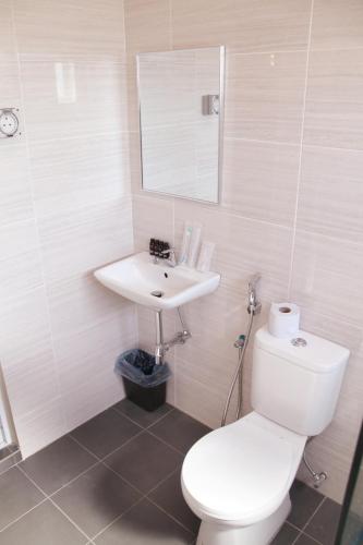a bathroom with a white toilet and a sink at Gergasi Inn in Ipoh