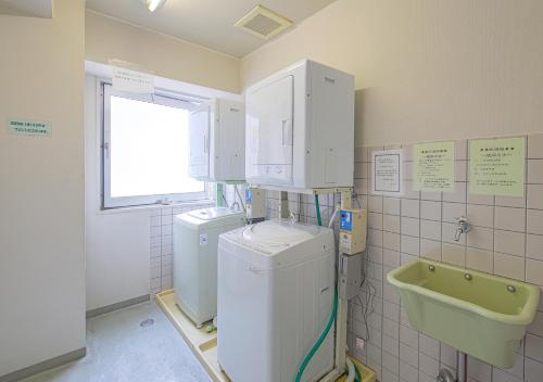 uma lavandaria com duas lavagens e um lavatório em Hotel Airport Komatsu em Komatsu