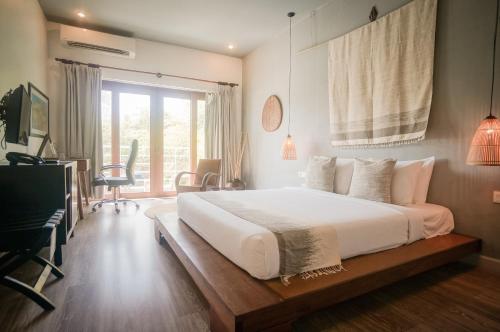 a bedroom with a large bed and a large window at iRoHa Garden Hotel & Resort in Phnom Penh