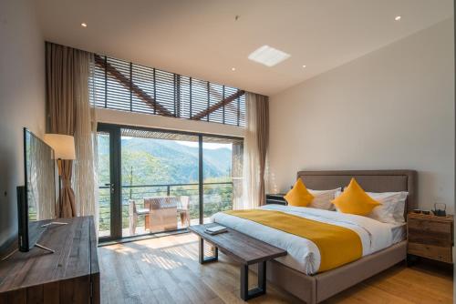 a bedroom with a bed and a large window at The Western Clouds in Deqing