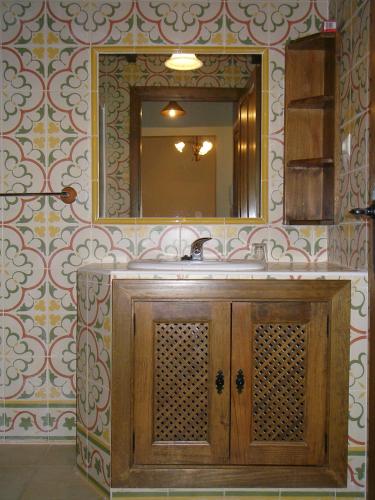 a bathroom with a sink and a mirror at Apartamentos Los Hebiles in Jerte