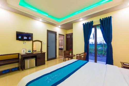 1 dormitorio con 1 cama grande y TV en Hào Anh Villa Hội An, en Hoi An