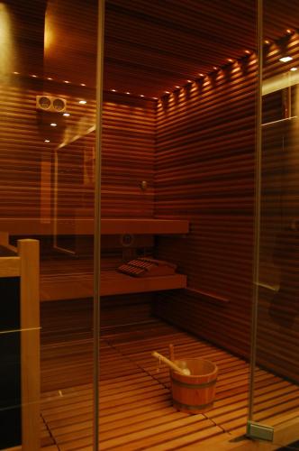 a sauna with a wooden floor and a bucket at Hotel & SPA Riviera Castelsardo in Castelsardo
