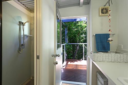 a bathroom with a door leading to a patio at Barefoot Bungalow - Castaways Beach in Sunrise Beach