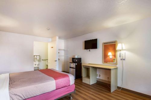 a small hotel room with a bed and a desk at Motel 6-Vancouver, WA in Vancouver