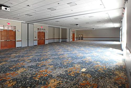 an empty room with a colorful carpet on the floor at Wyndham Garden State College in State College
