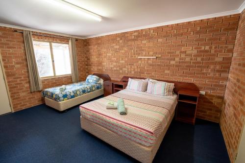 ein kleines Zimmer mit einem Bett und einem Sofa in der Unterkunft Gascoyne Hotel in Carnarvon