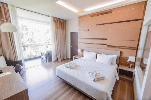 1 dormitorio con 1 cama blanca y 2 toallas en Lembang Asri Resort, en Lembang