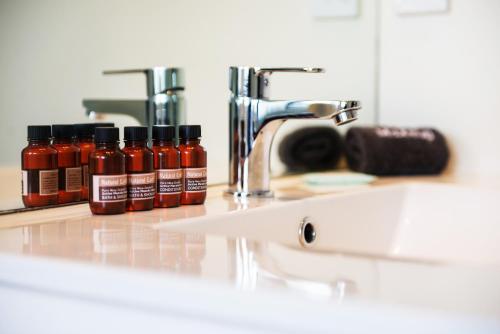 a counter with four bottles of chili sauce on it at 123 Motel in Christchurch