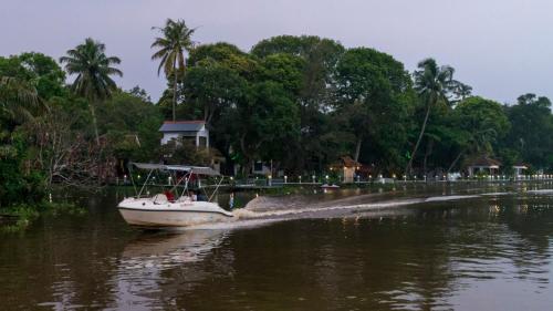 a small boat in the water on a river at Warmth Lake Haven in Alleppey