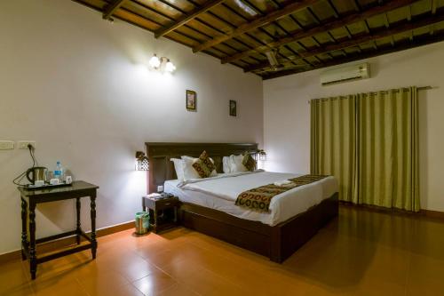 a bedroom with a bed and a table in a room at Warmth Lake Haven in Alleppey