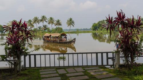 a boat with people in it on a river at Warmth Lake Haven in Alleppey