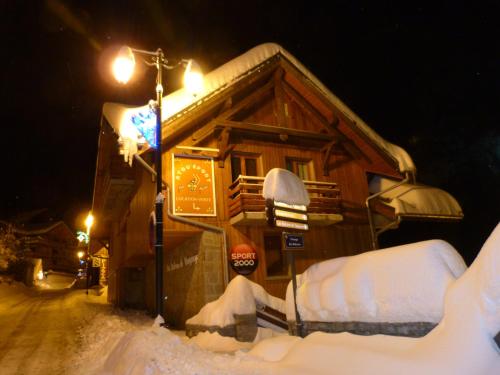 a house covered in snow next to a street light at Les Balcons de Vaujany in Vaujany