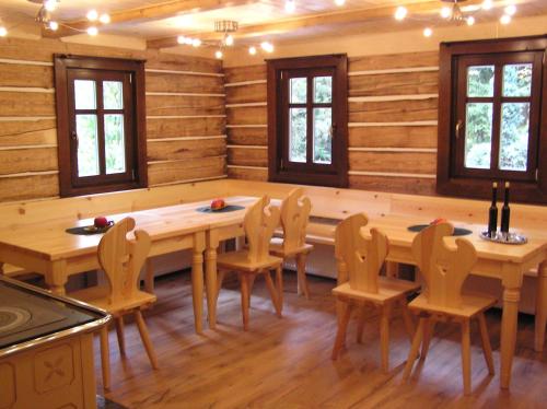 ein Esszimmer mit Holzwänden sowie einem Tisch und Stühlen in der Unterkunft Balada horská chata in Bedřichov