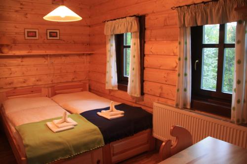 1 Schlafzimmer mit 2 Betten in einem Blockhaus in der Unterkunft Balada horská chata in Bedřichov