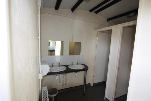 uma casa de banho com 2 lavatórios e um espelho em The White Horse Inn Bunkhouse em Threlkeld
