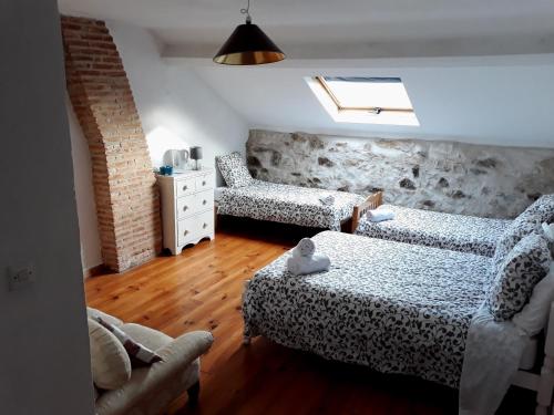 Habitación con 2 camas, sofá y silla en Le Puy Robin, en La Souterraine