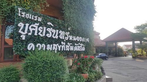 a sign on the side of a building with plants at Busyarin Hotel in Nong Khai