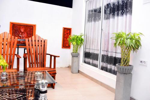 a dining room with two chairs and a table with plants at Indunil place hiriketiya in Dickwella