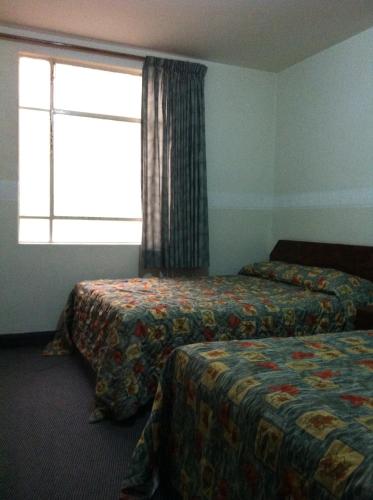 a hotel room with two beds and a window at Hotel Dos Naciones in Mexico City