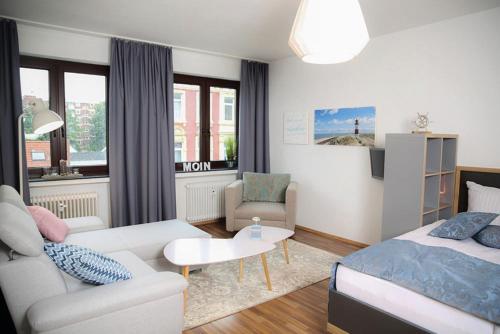 ein Wohnzimmer mit Sofa und Bett in der Unterkunft Schiller-Quartier 15 in Bremerhaven